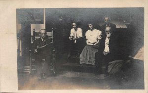 RPPC MAN READING NEWSPAPER FAMILY ON PORCH GEORGIA REAL PHOTO POSTCARD (c. 1905)