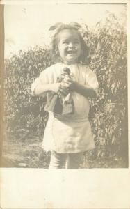 c1910 RPPC Postcard Laughing Little Girl With Homemade Doll Unknown US