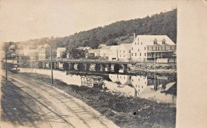 RIVER EDGE TOWN-BUILDINGS-RAILROAD BRIDGE~1900s REAL PHOTO POSTCARD