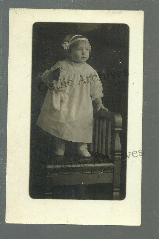 RPPC c1910 LITTLE GIRL Holding TEDDY BEAR Posing CHAIR Studio Shot PARTY DRESS