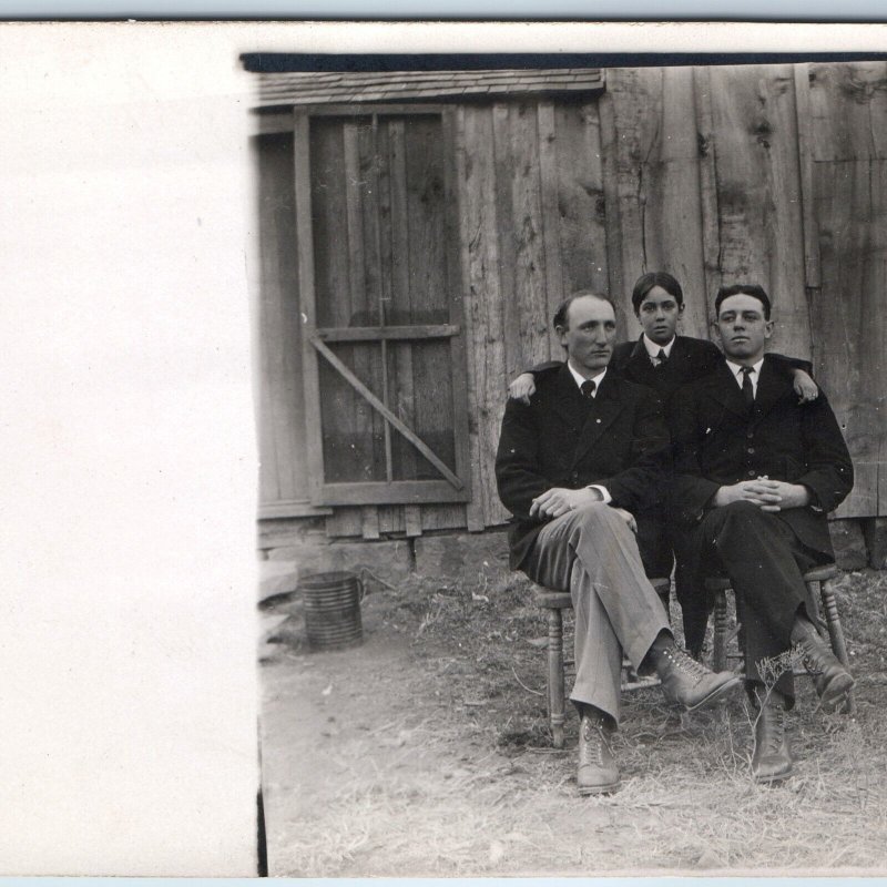 c1910s Handsome Group Men RPPC Pose Farm Chair Rustic Barn Plank Wall House A213