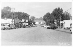 H58/ Ennis Montana RPPC Postcard c1950s Main St Chevrolet Dealer Mobil Gas