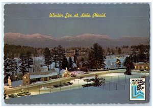 c1960's Winter Eve At Lake Placid Lighted Trees Car Park North Elba NY Postcard 
