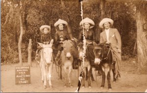 Real Photo Postcard Family of Four Riding Donkey's Wearing Hats Colorado Springs