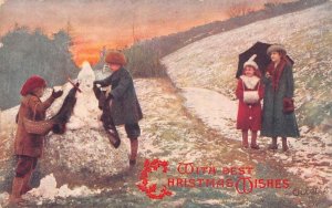 CHRISTMAS HOLIDAY SNOWMAN ON ROCK CHILDREN UK ENGLAND POSTCARD (c. 1908)