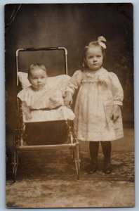 1909 Little Girl And Baby On Stroller Studio Napoleon Ohio RPPC Photo Postcard