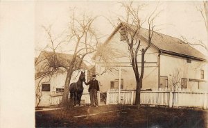 RPPC MAN IN UNIFORM WITH HORSE HOUSES FARM REAL PHOTO POSTCARD (c.1910)
