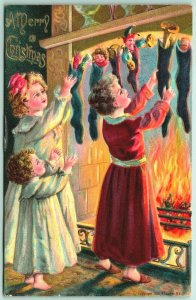 Children w Toys in Stockings Fireplace Merry Christmas Embossed DB Postcard I10