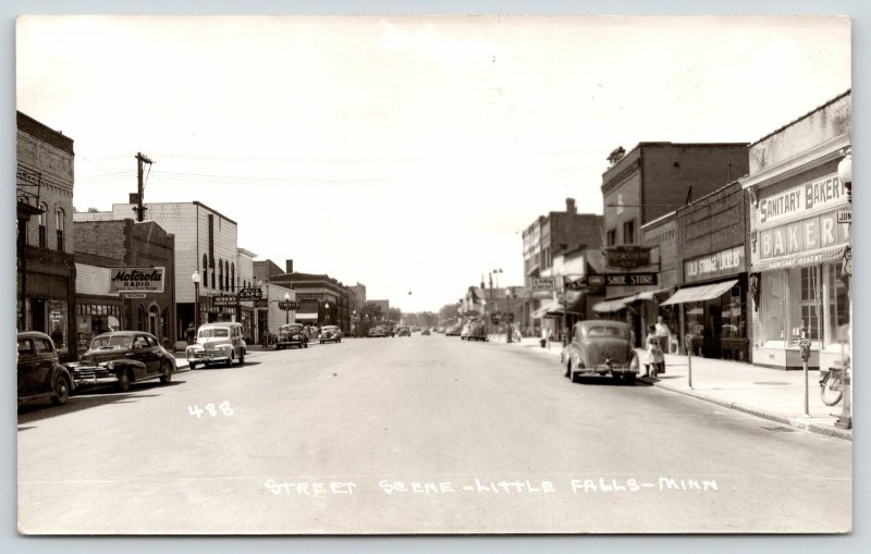 Little Falls MN~Main Street~Sanitary Bakery~Cafe~Record Store~1940s Woody~RPPC 