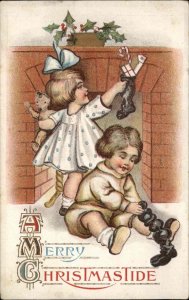 Christmas Little Girl and Boy Stockings at Fireplace Teddy Bear c1910 Postcard