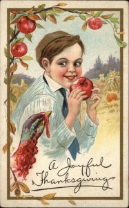 THANKSGIVING Little Boy Eats Apple While Turkey Looks On c1910 Postcard