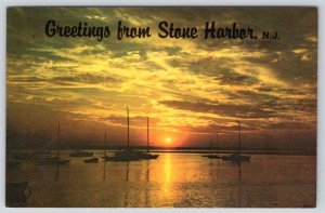 1985 GREETINGS FROM STONE HARBOR NEW JERSEY NJ BOAT ON THE WATER SUNSET POSTCARD