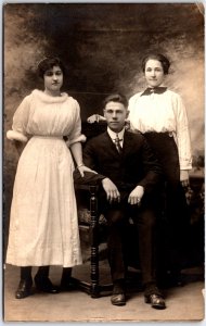 Man in Suit with Tie and Two Women in Formal Dress Portrait - Vintage Postcard