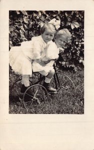 YOUNG CHILDREN-BOY-GIRL-RIDING OLD TRICYCLE~1910s REAL PHOTO POSTCARD