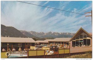 Patrons relax next to swimming pool at Lazy T Motel, overlooking Lake Estes, ...