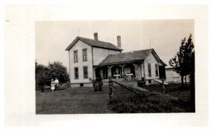 Old Black and White Photo of man and woman outside of their home RPPC Postcard