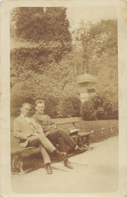 Vintage photo postcard of two men sitting on a bench