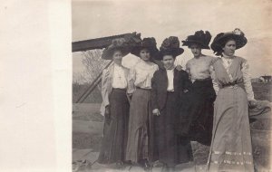 RPPC FIVE WOMEN BIG FLOWERY HATS MACHINERY REAL PHOTO POSTCARD (c. 1910)
