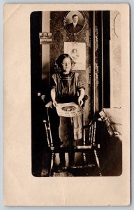 Real Photo Postcard~Victorian Girl Holds Baby Rose Picture~Dad on Wall~1910 RPPC