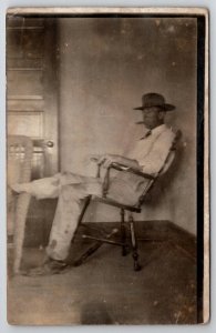 RPPC Amputee Leg Man Smoking Cigar on Broken Chair Real Photo Postcard G29