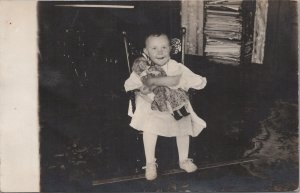 RPPC Postcard Little Girl Hugging Doll in Spotted Dress