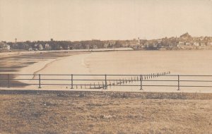 VIEW ACROSS BEACH & WATER TO VILLAGE ON OPPOSITE SHORE~1900s REAL PHOTO POSTCARD