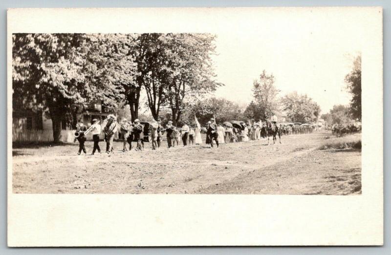 Sepia RPPC Town Sidewalk March~Led by Saxophone~Trombone~Tuba~Trumpet~Flag c1910 