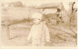 c.1901-07 Little Boy w/ Stocking Hat Wincing by Barn Real Photo 10C1-427 