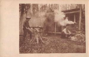 Camping Scene Woman building Fire Man Chopping Wood Antique Postcard J76214