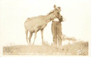 1920s RPPC Warden D. Davidson Feeds Elk Named Maud, Buffalo Park Alberta Canada