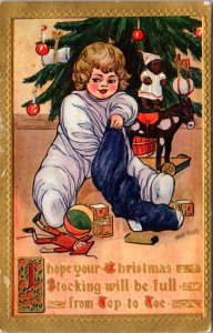 Christmas Postcard Young Child Pulling Presents Out of Stocking Candlelit Tree