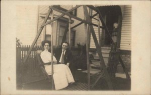 Man and Woman on Antique Swing Bench c1910 Real Photo Postcard