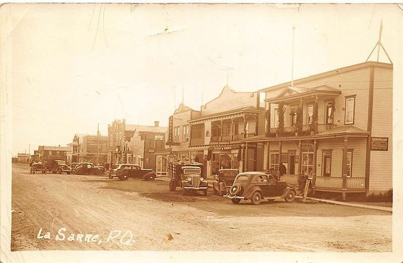 La Sarre Quebec Dirt Street Storefront Old Cars Truck in 1938 Real Photo PC