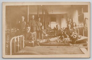 RPPC WW1 US Soldiers Lounging In Barracks Flagg Real Photo Postcard M26