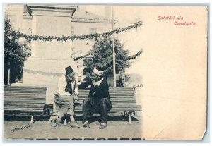 c1905 Two Men Sitting and Talking Greetings from Constanta Romania Postcard