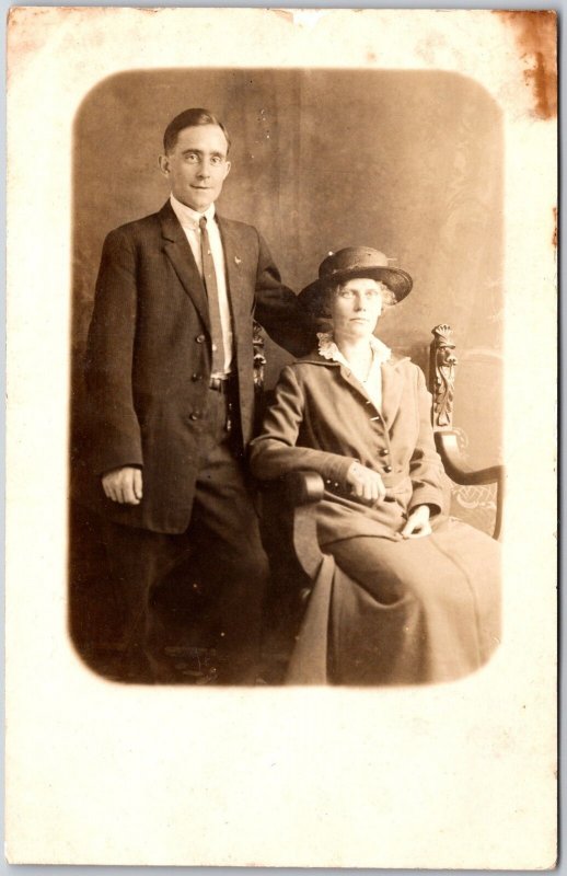 Couple Woman Sitting on Chair Man Standing Beside Her Real Photo RPPC Postcard 