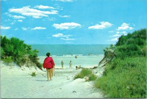 postcard unknown beach scene - Woman in red jacket walking to beach