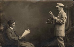 Camera Studio Image Photographer Man Reading Paper c1910s Real Photo Postcard