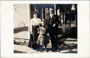 Family in front of porch - mother, father, daughter - Cyko rppc