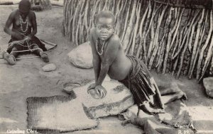 SOUTH AFRICA~ZULULAND-YOUNG BOY GRINDING CORN ON ROCKS~PHOTO POSTCARD