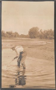 RPPC MAN SMOKING CIGARETTE & FISHING NEBRASKA REAL PHOTO POSTCARD (c. 1910)