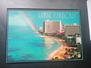 Postcard Sunrise Rainbow beyond The Sheraton Hotel in  Waikiki, Hawaii.