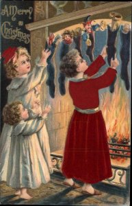 Christmas Children Hang Stockings Real Red Silk Clothing c1910 Postcard