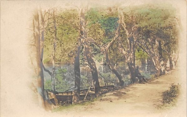 Man sitting against tree along the water in Bridgeton, New Jersey