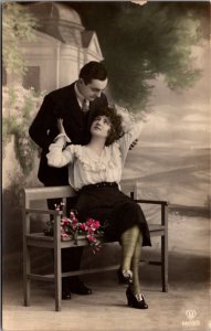 Hand Colored Real Photo Studio Postcard Man and Woman Sitting on Bench Embracing