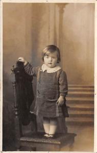 Young child standing in chair Child, People Photo Writing on back 