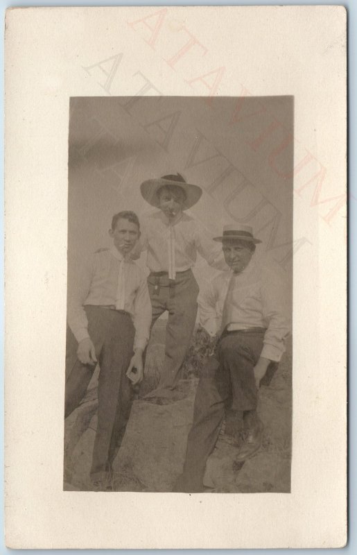 c1910s Group Cool Men Smoking RPPC Outdoors Friends Fun Guys Chillin Hat PC A212