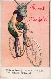 PROSIT NEUHAHR-HORNED ANIMAL HEAD WOMAN ON BICYCLE-DASS DU KANNST FAHRE~POSTCARD