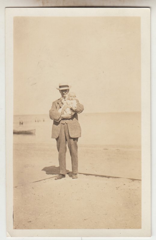 P2887 old postcard azoa RPPC man holding baby on beach by water