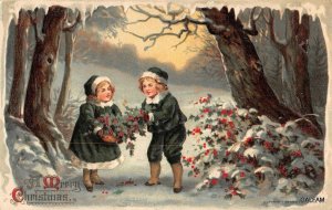 children picking holly in woods c1910 Christmas postcard